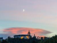 Schloß Hohenaschau mit rötlicher Wolke dahinter und Mondsichel am Abendhimmel